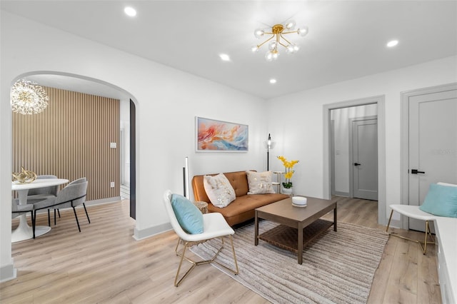 living room featuring light hardwood / wood-style flooring and an inviting chandelier