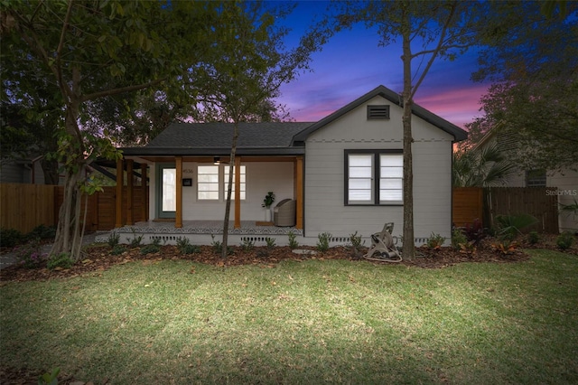 view of front of house with covered porch and a lawn