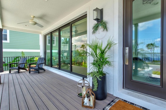 wooden deck featuring covered porch and ceiling fan