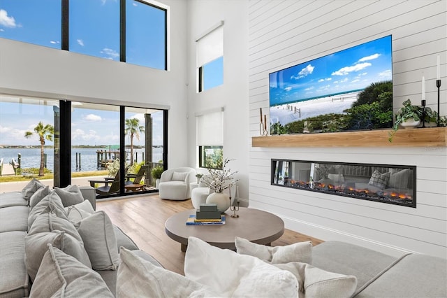 living room with wood walls, wood-type flooring, and a high ceiling