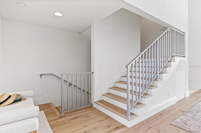 stairs featuring hardwood / wood-style floors