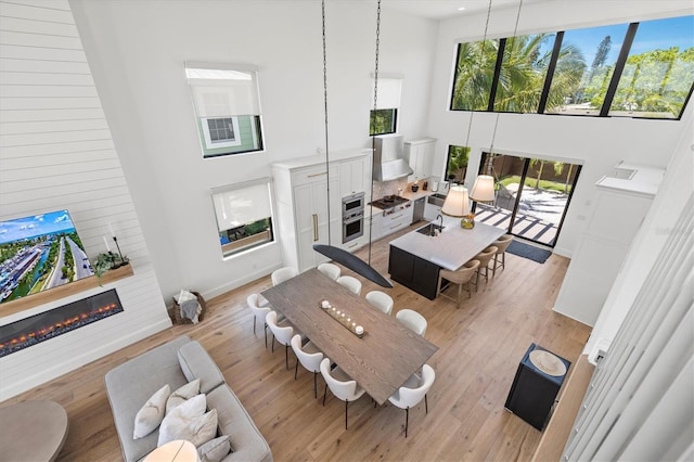 living room with a towering ceiling and light wood-type flooring