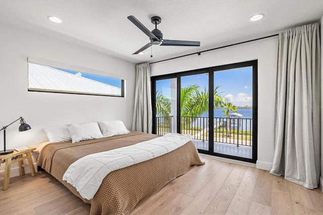 bedroom with a water view, ceiling fan, access to exterior, and light wood-type flooring