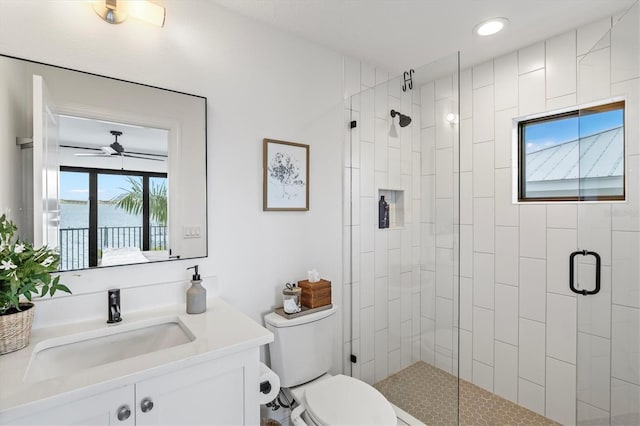 bathroom with toilet, an enclosed shower, a water view, vanity, and ceiling fan