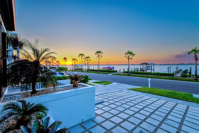 patio terrace at dusk featuring a water view