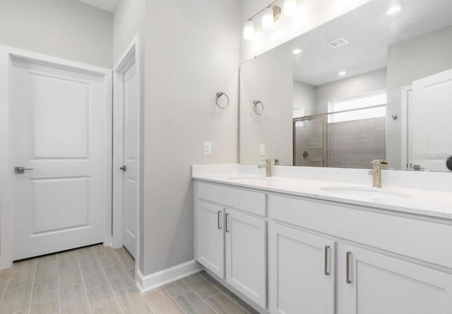 bathroom with vanity and a shower with door