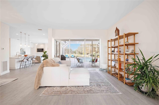 living room featuring sink and light hardwood / wood-style floors