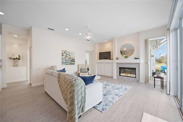 living room featuring recessed lighting, visible vents, a ceiling fan, light wood-type flooring, and baseboards