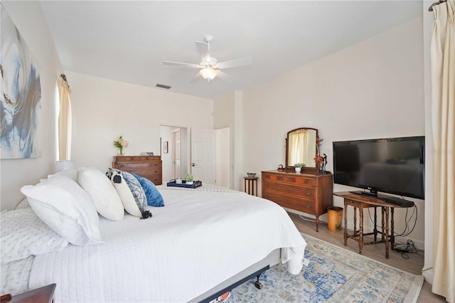 bedroom with ceiling fan, wood finished floors, and visible vents