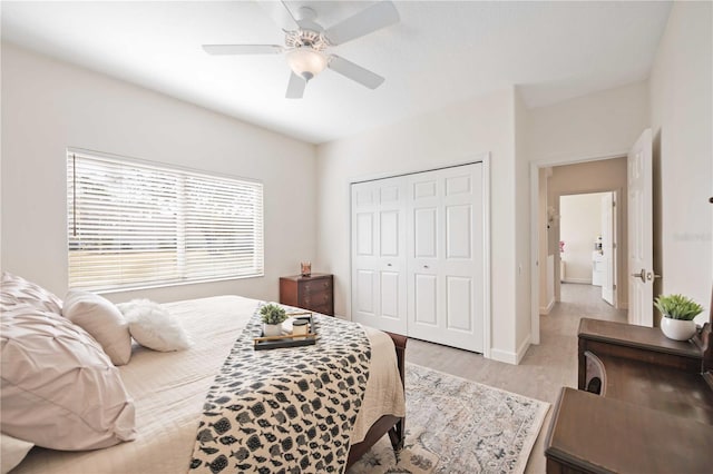 bedroom with ceiling fan, light wood-type flooring, and a closet