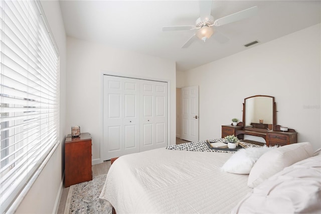 bedroom featuring ceiling fan, a closet, visible vents, and baseboards