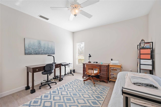 office area with a ceiling fan, visible vents, and baseboards