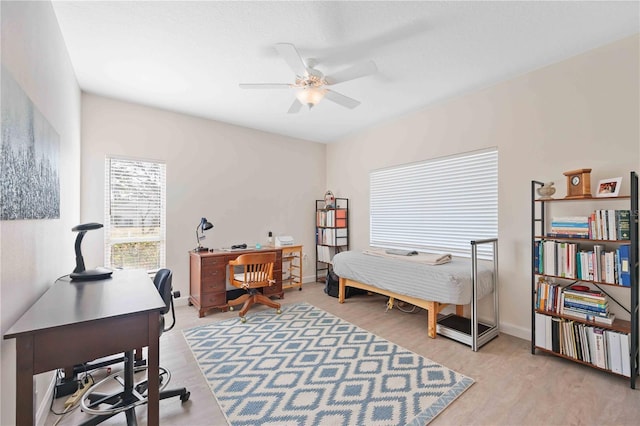 bedroom featuring baseboards, ceiling fan, and light wood-style floors