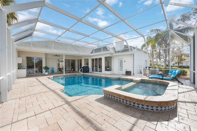 view of pool with a lanai, a patio, and an in ground hot tub