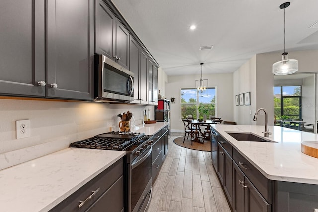 kitchen with sink, pendant lighting, appliances with stainless steel finishes, and a wealth of natural light