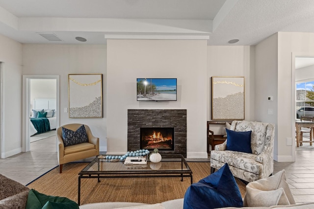 living room with a stone fireplace and hardwood / wood-style flooring