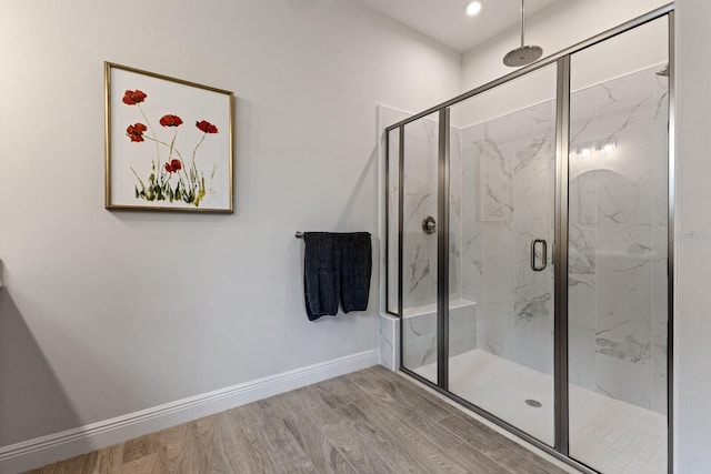 bathroom with a shower with shower door and hardwood / wood-style floors