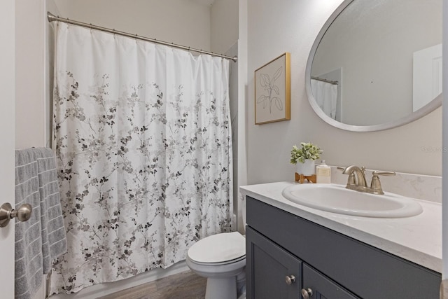 bathroom with toilet, vanity, and hardwood / wood-style flooring