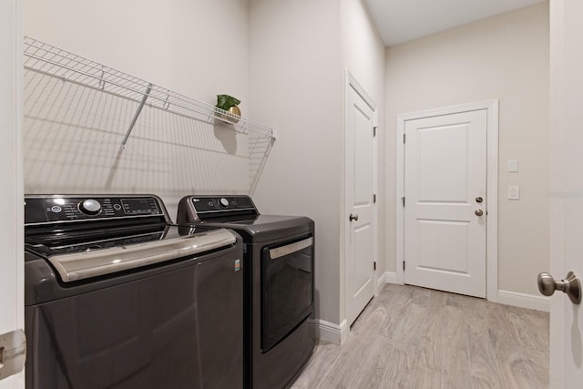 clothes washing area with light hardwood / wood-style floors and independent washer and dryer