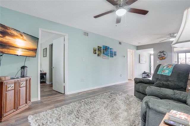 living room featuring ceiling fan and hardwood / wood-style floors