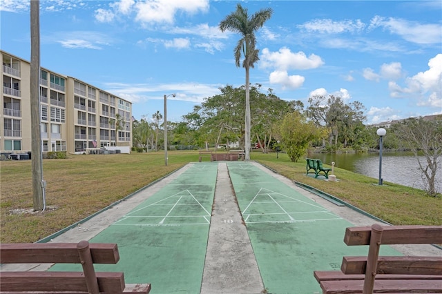 view of home's community featuring a water view and a lawn