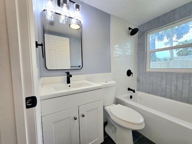 full bathroom with toilet, tiled shower / bath combo, tile patterned flooring, and vanity