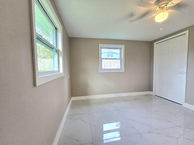 unfurnished bedroom featuring ceiling fan and a closet