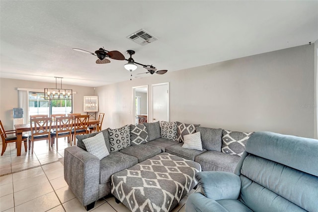 tiled living room with ceiling fan with notable chandelier