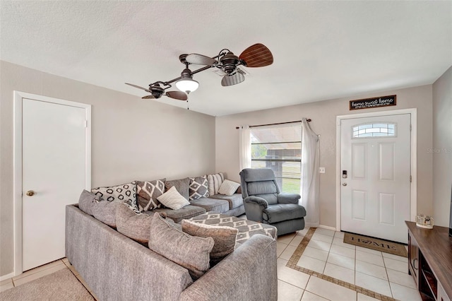 living room featuring light tile patterned flooring, ceiling fan, and a textured ceiling