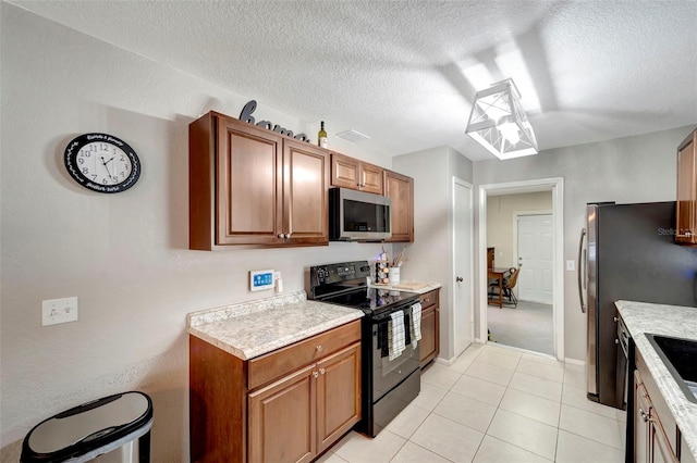 kitchen featuring light tile patterned floors, electric range, and a textured ceiling