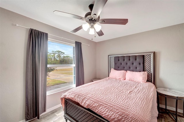 bedroom with multiple windows, ceiling fan, and light hardwood / wood-style flooring