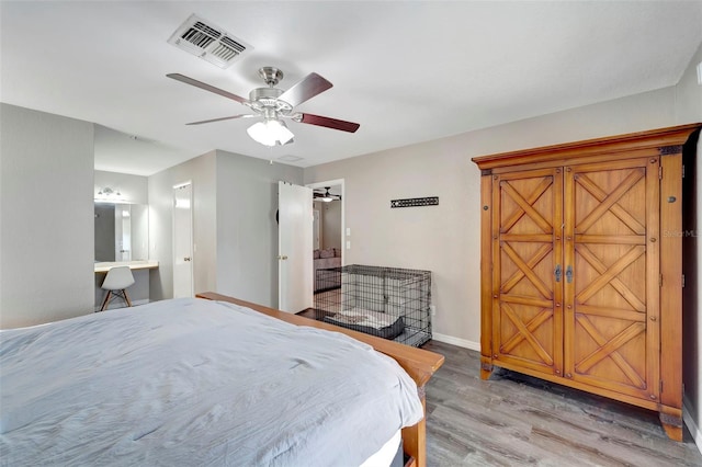 bedroom featuring connected bathroom, light hardwood / wood-style floors, and ceiling fan