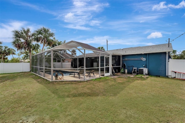 rear view of property featuring a patio, a lawn, cooling unit, a lanai, and a fenced in pool