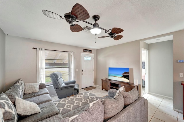 living area with baseboards, a ceiling fan, a textured ceiling, and light tile patterned flooring