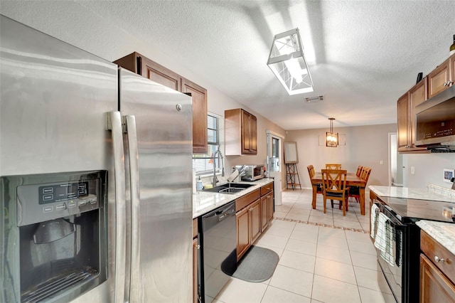 kitchen featuring brown cabinets, visible vents, a sink, and black appliances