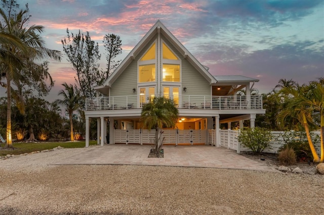 back house at dusk featuring a carport