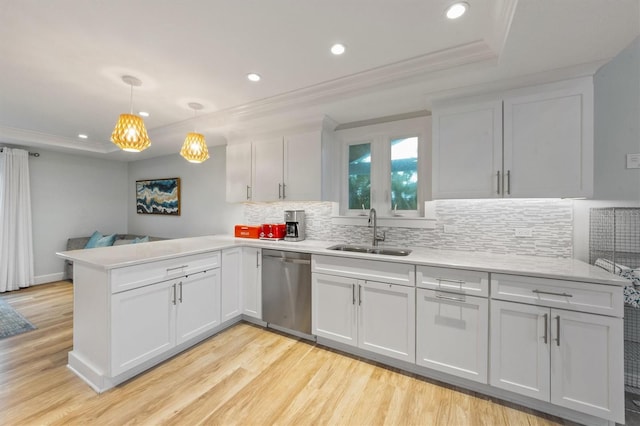 kitchen with dishwasher, decorative light fixtures, sink, kitchen peninsula, and a raised ceiling