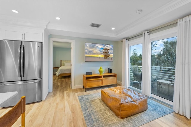 living room with light hardwood / wood-style flooring and crown molding