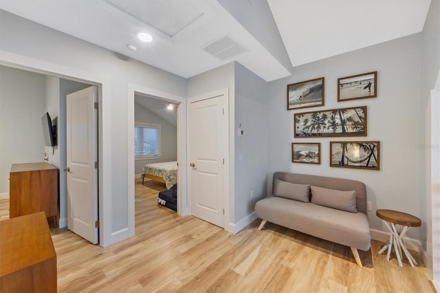 sitting room featuring vaulted ceiling and light hardwood / wood-style flooring