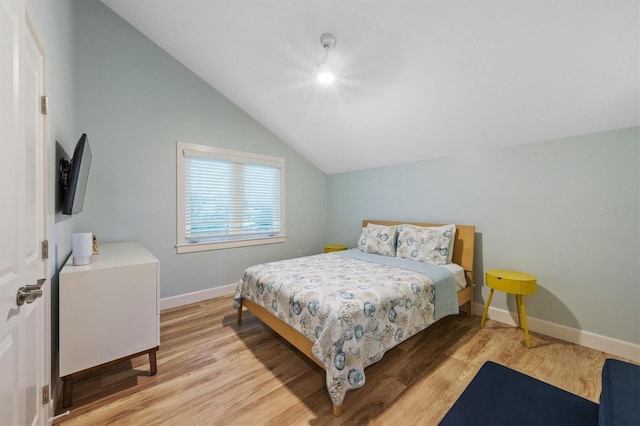 bedroom with light hardwood / wood-style floors and vaulted ceiling