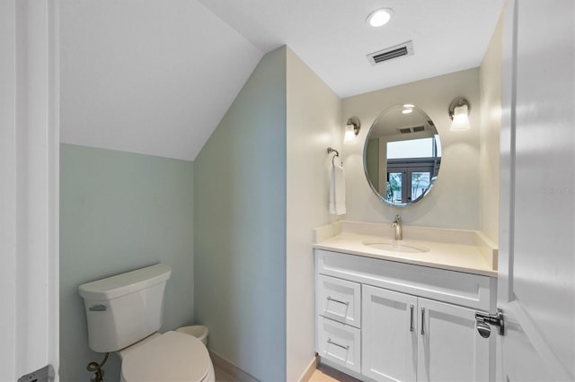 bathroom featuring lofted ceiling, vanity, and toilet