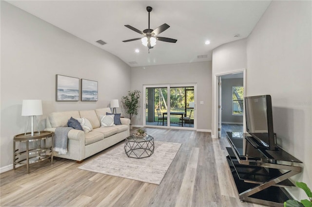 living room with ceiling fan, lofted ceiling, and light wood-type flooring