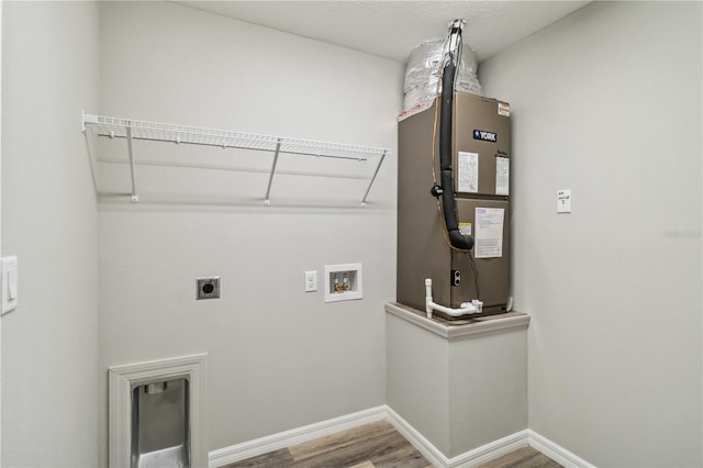 clothes washing area with washer hookup, hardwood / wood-style floors, heating unit, and hookup for an electric dryer