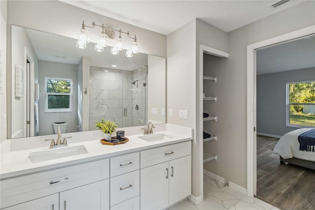 bathroom featuring a shower with door, vanity, a healthy amount of sunlight, and toilet