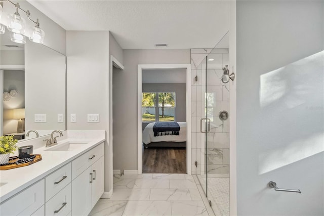 bathroom with vanity, a shower with shower door, and a textured ceiling