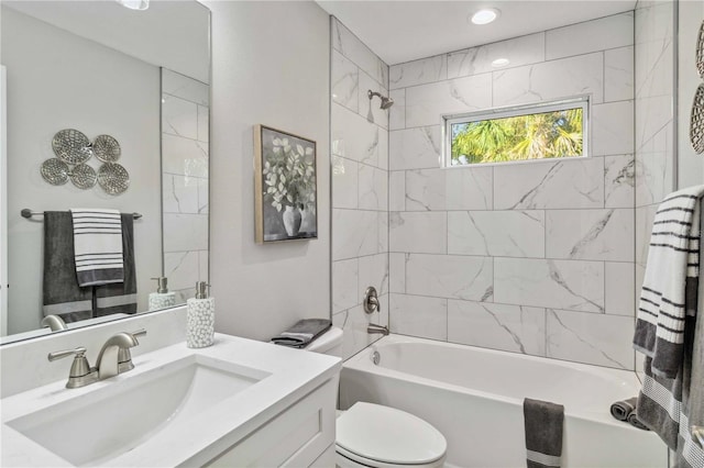 full bathroom with tiled shower / bath combo, vanity, and toilet