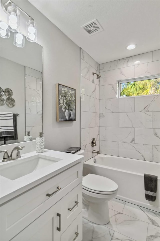 full bathroom with vanity, toilet, and tiled shower / bath combo