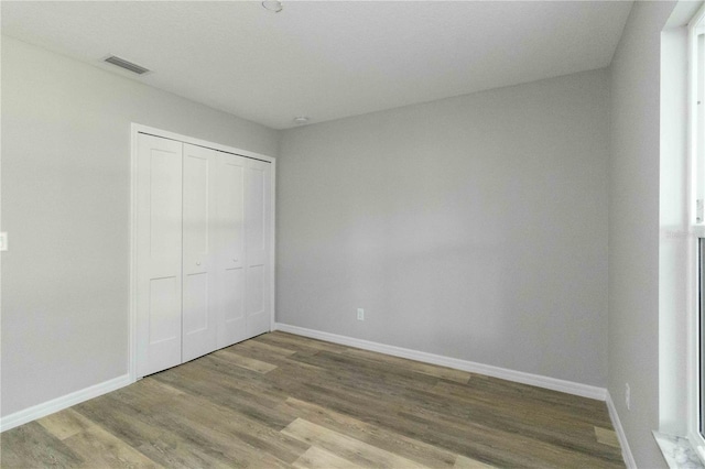 unfurnished bedroom with hardwood / wood-style flooring and a closet