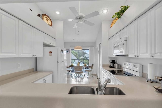 kitchen featuring white appliances, white cabinets, sink, vaulted ceiling, and ceiling fan