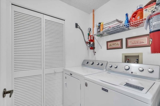 washroom featuring a textured ceiling and washer and clothes dryer